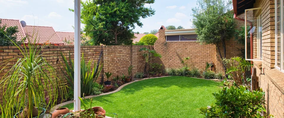 Jardin de maison individuelle avec haie et terrasse, terrain type de la gamme Landroid.